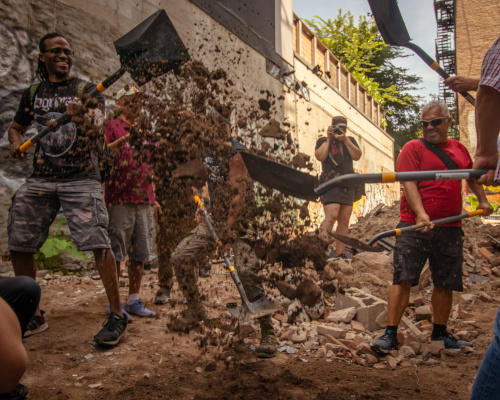 photo of five shovels digging and dirt flying in the air